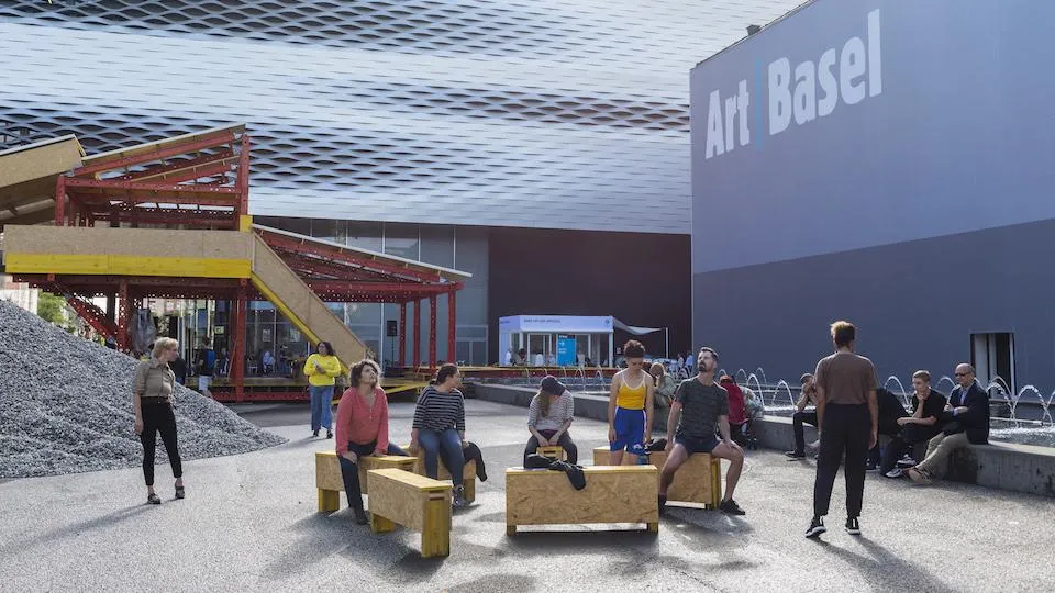 People in Messeplatz with Art Basel logo on building