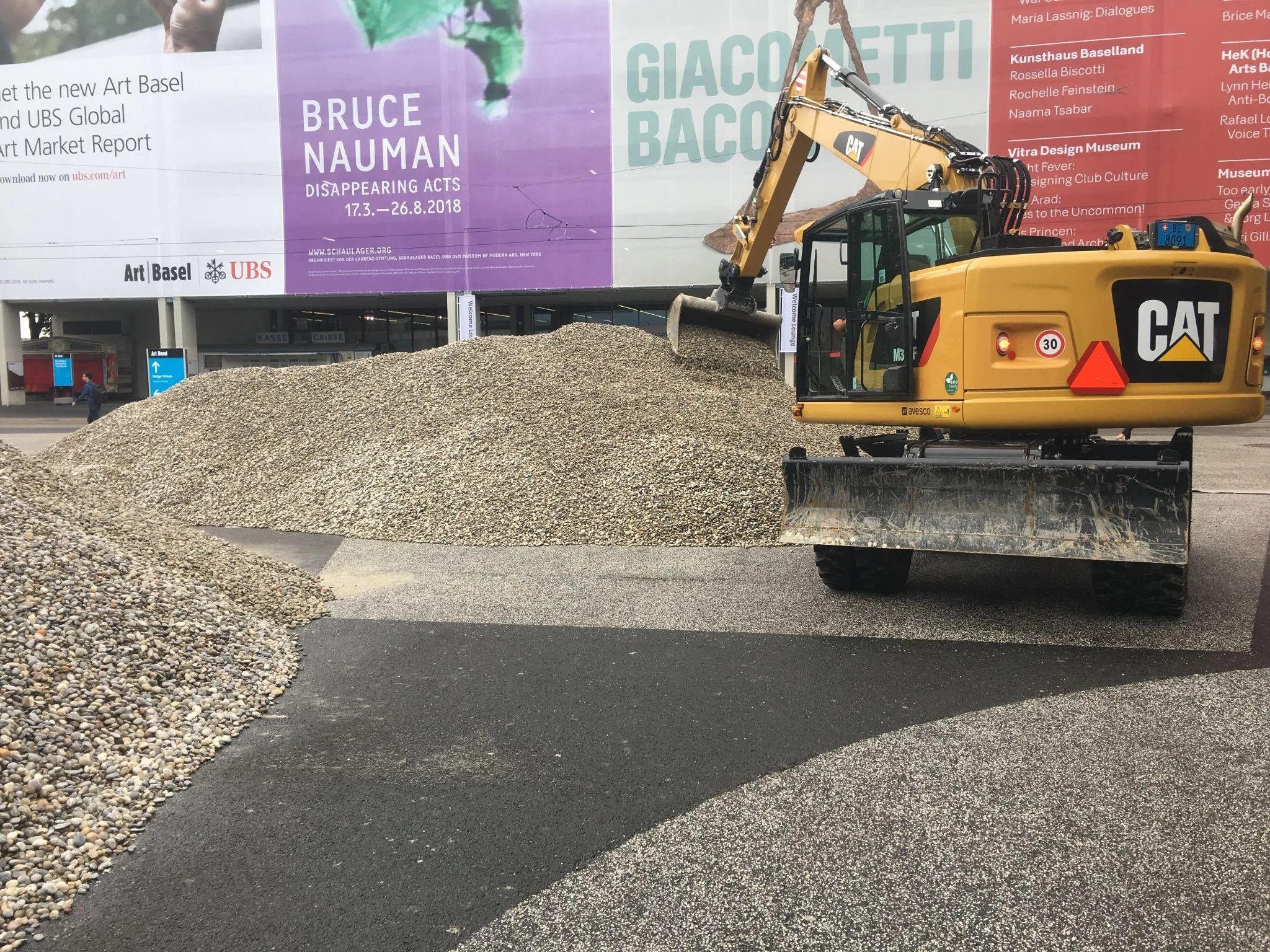 CAT digger moving rocks for sculpture