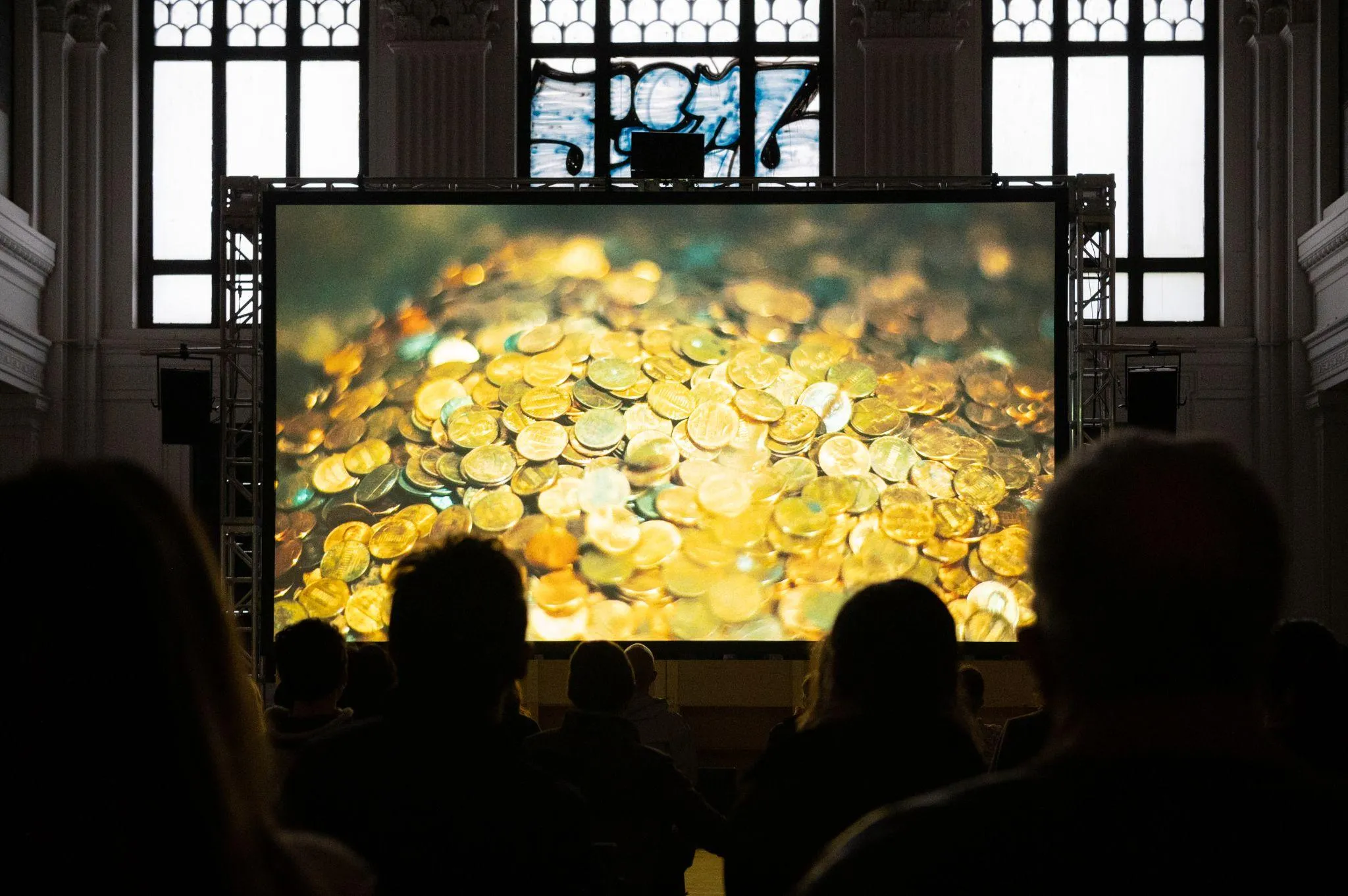 View of screen with projections of a pile of pennies, inside the building